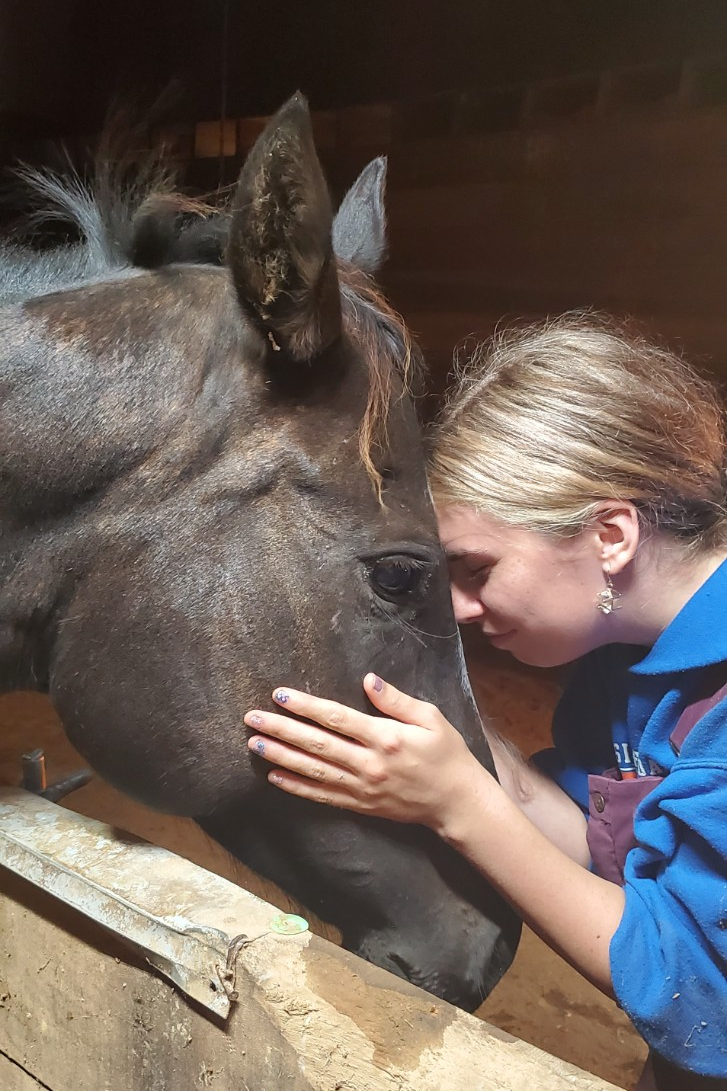 Jessica lovingly bonding with her horse Moonshine sharing a forehead-to-forehead moment